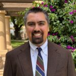 Jacob Poore headshot. He is outside on a sunny day.