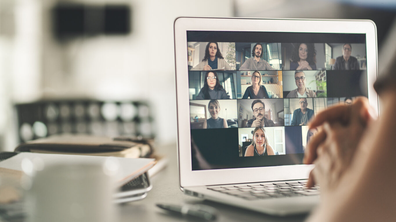 A laptop computer screen displays an active webinar with dozens of attendees.